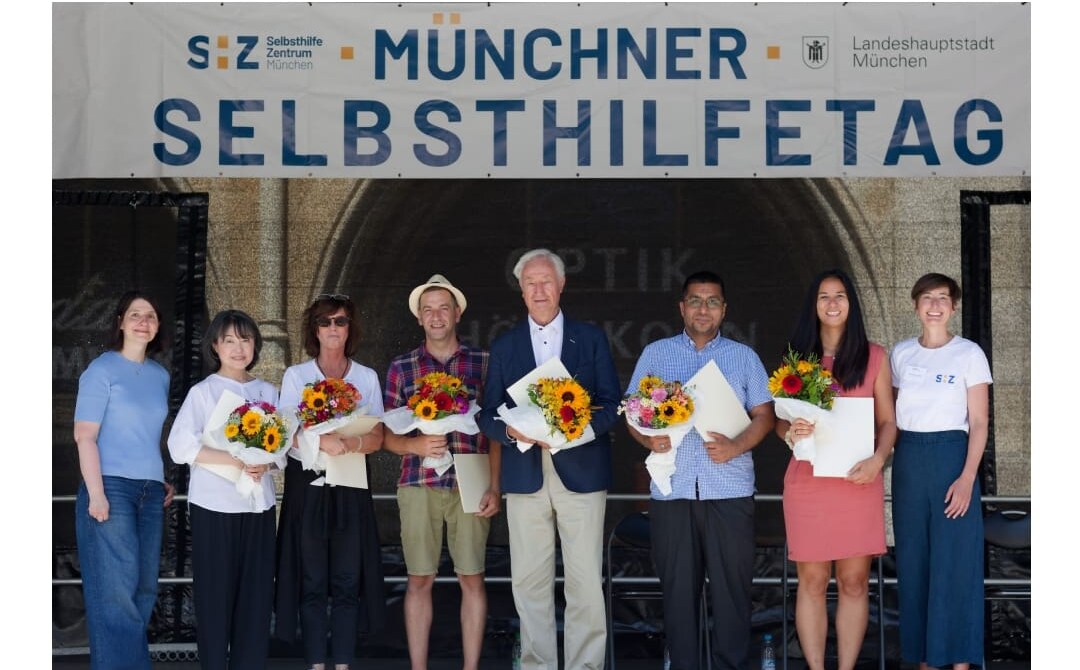 Award ceremony for "München dankt" on stage at the Munich Self-Help Day